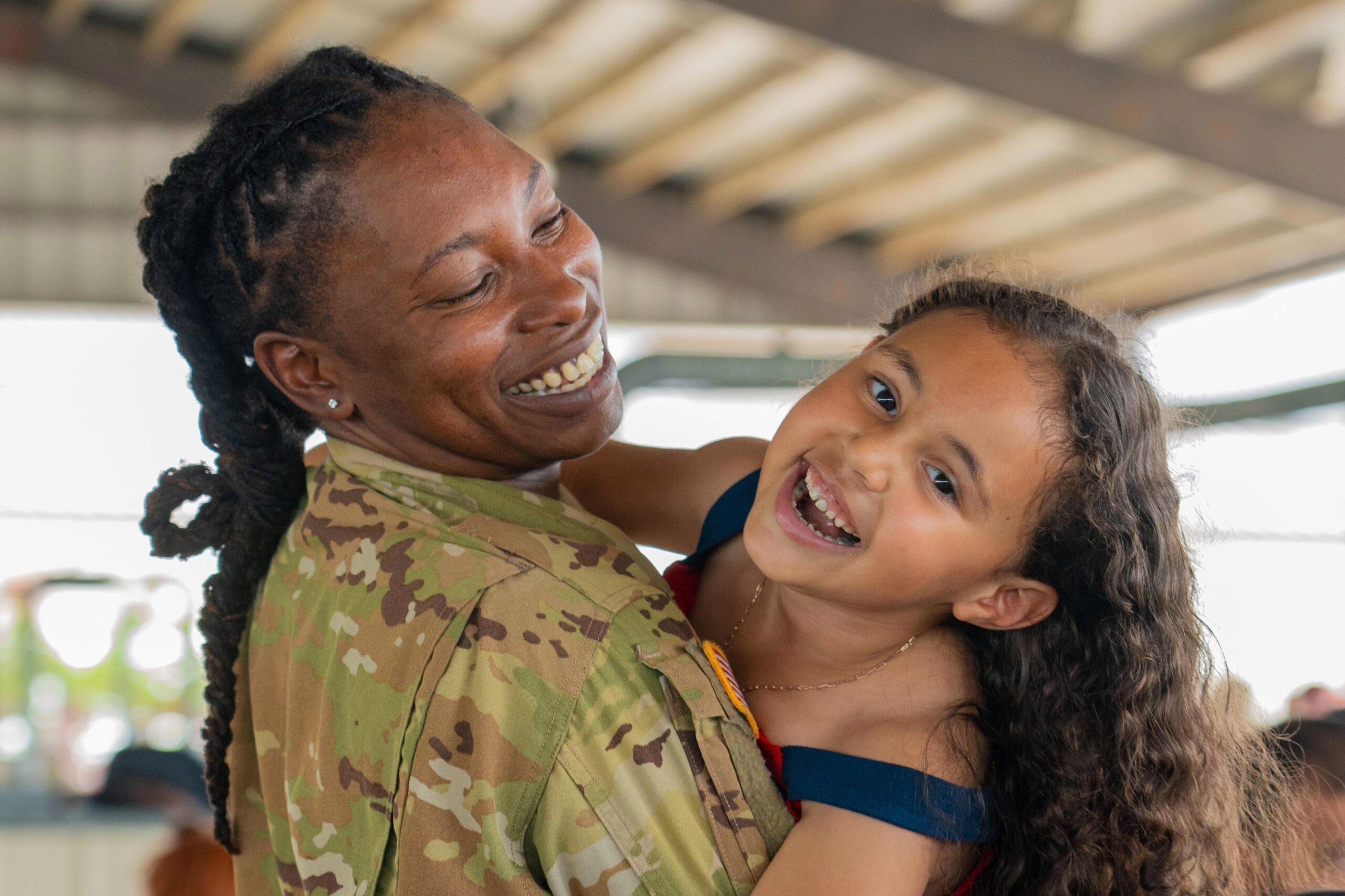 Smiling US Service Member with kid in their arms